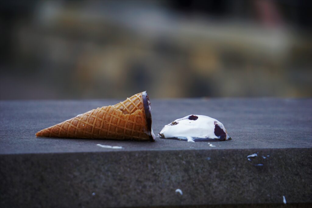 An ice cream cone on concrete ground